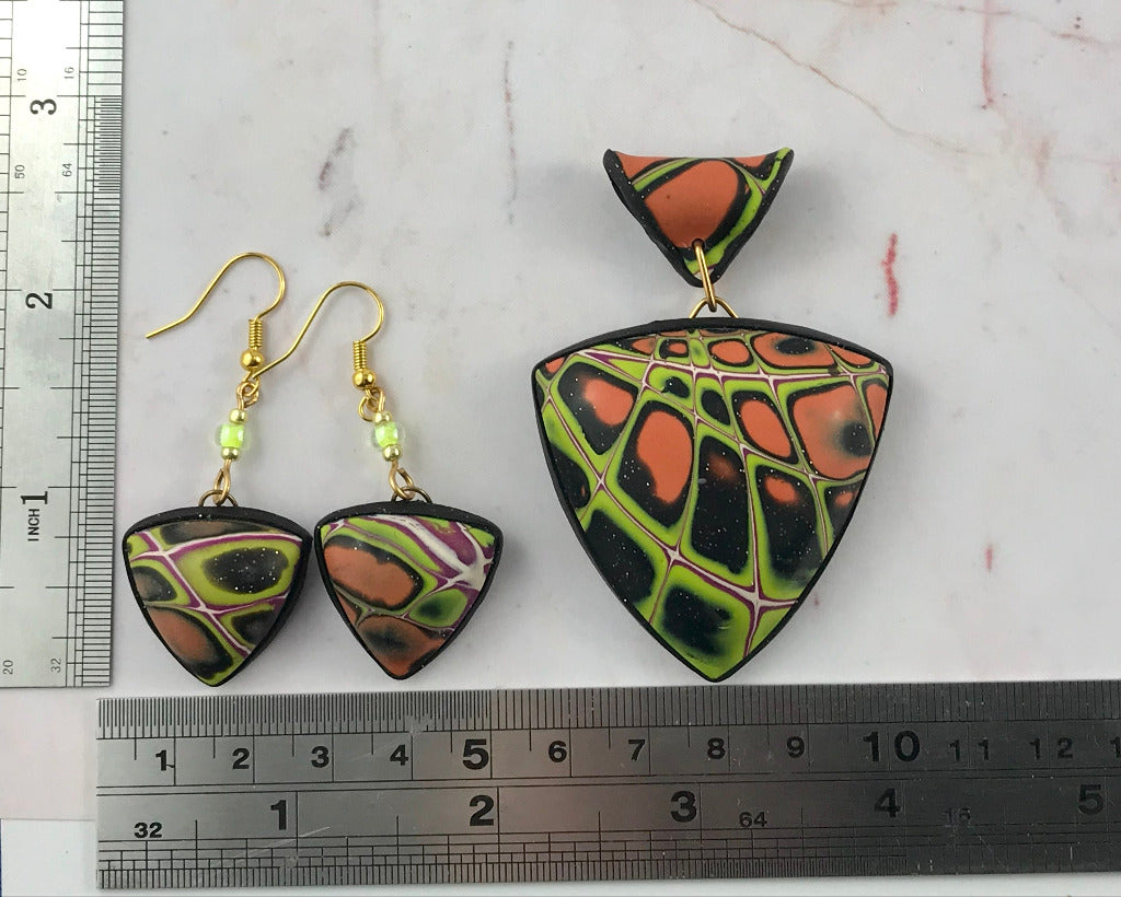 One of a kind handmade polymer clay jewellery set in Australia featuring bold orange green black pendant necklace, matching earrings and bracelet with unique abstract pattern and artisan design