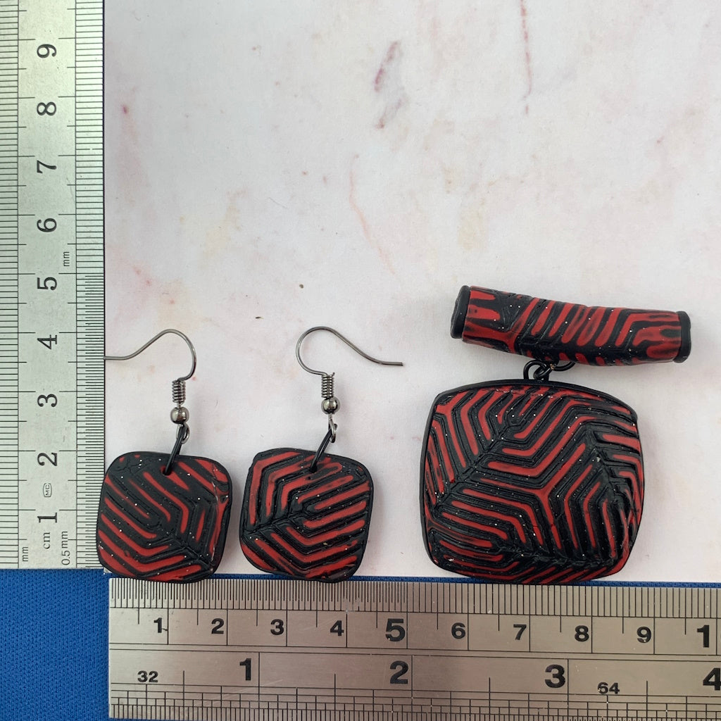 Red and black geometric pendant and earring set