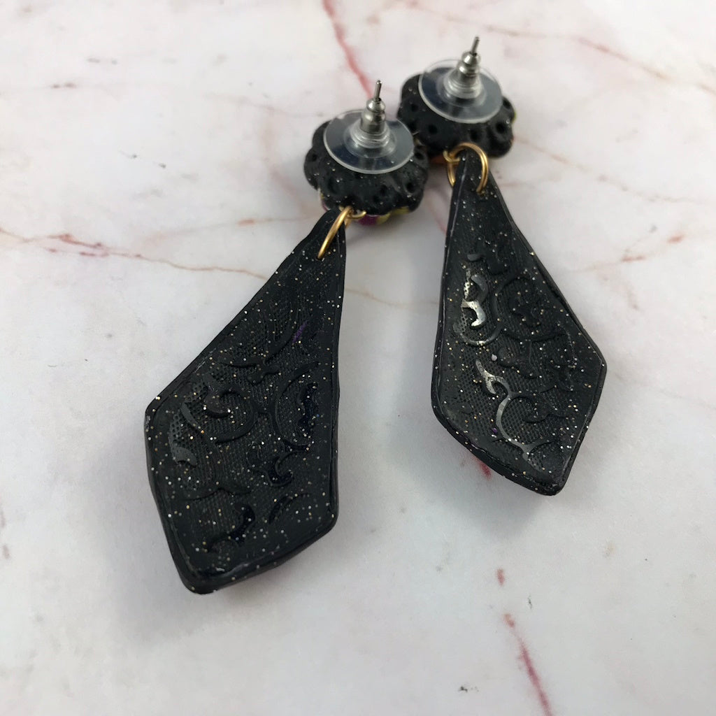 Back view of handmade long earrings with sparkly textured backing and covered post fittings.