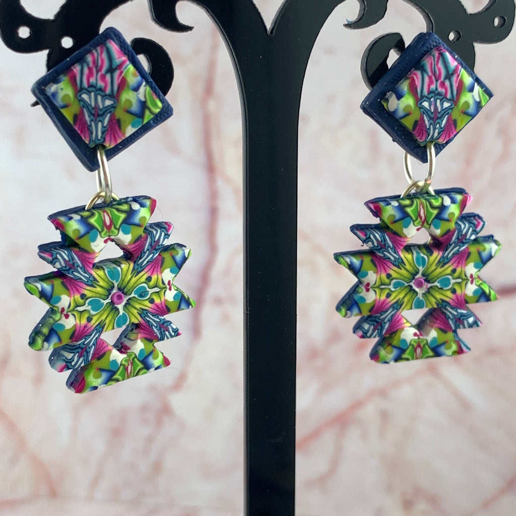 Front display of colourful handmade Australian Aztec inspired statement earrings with pink blue green geometric pattern.