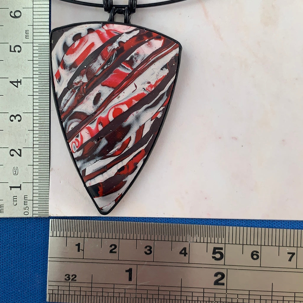 Award-winning Rennique polymer clay statement pendant necklace red black abstract design shown with ruler for size reference