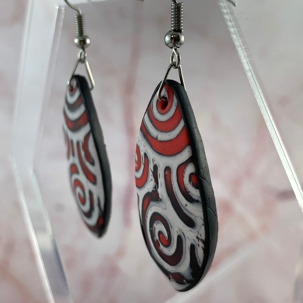 Lightweight handmade polymer clay statement earrings red white swirl pattern side view
