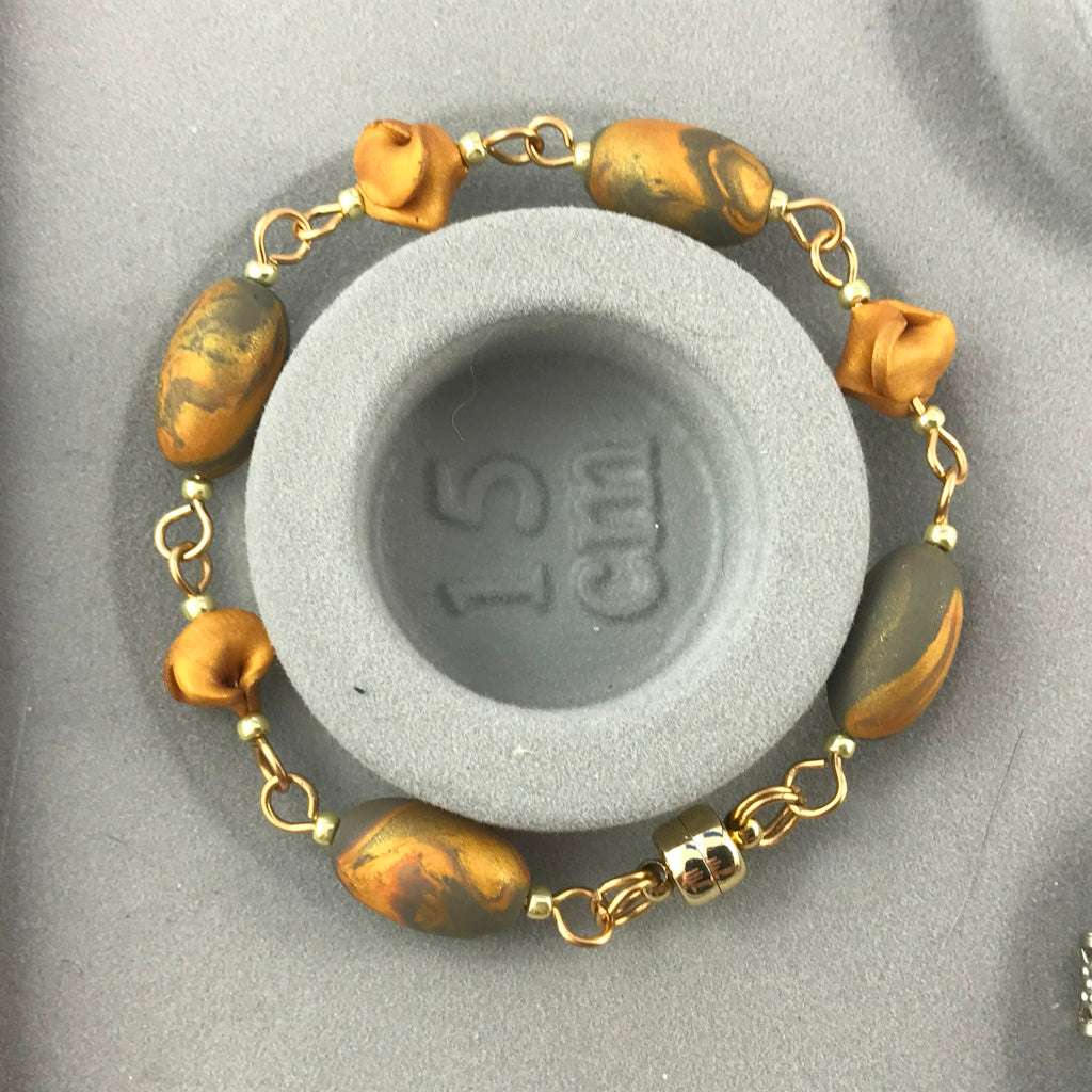 Handmade blue grey and gold bracelet displayed on 15 cm size stand with marbled polymer clay beads and elegant gold-toned findings.