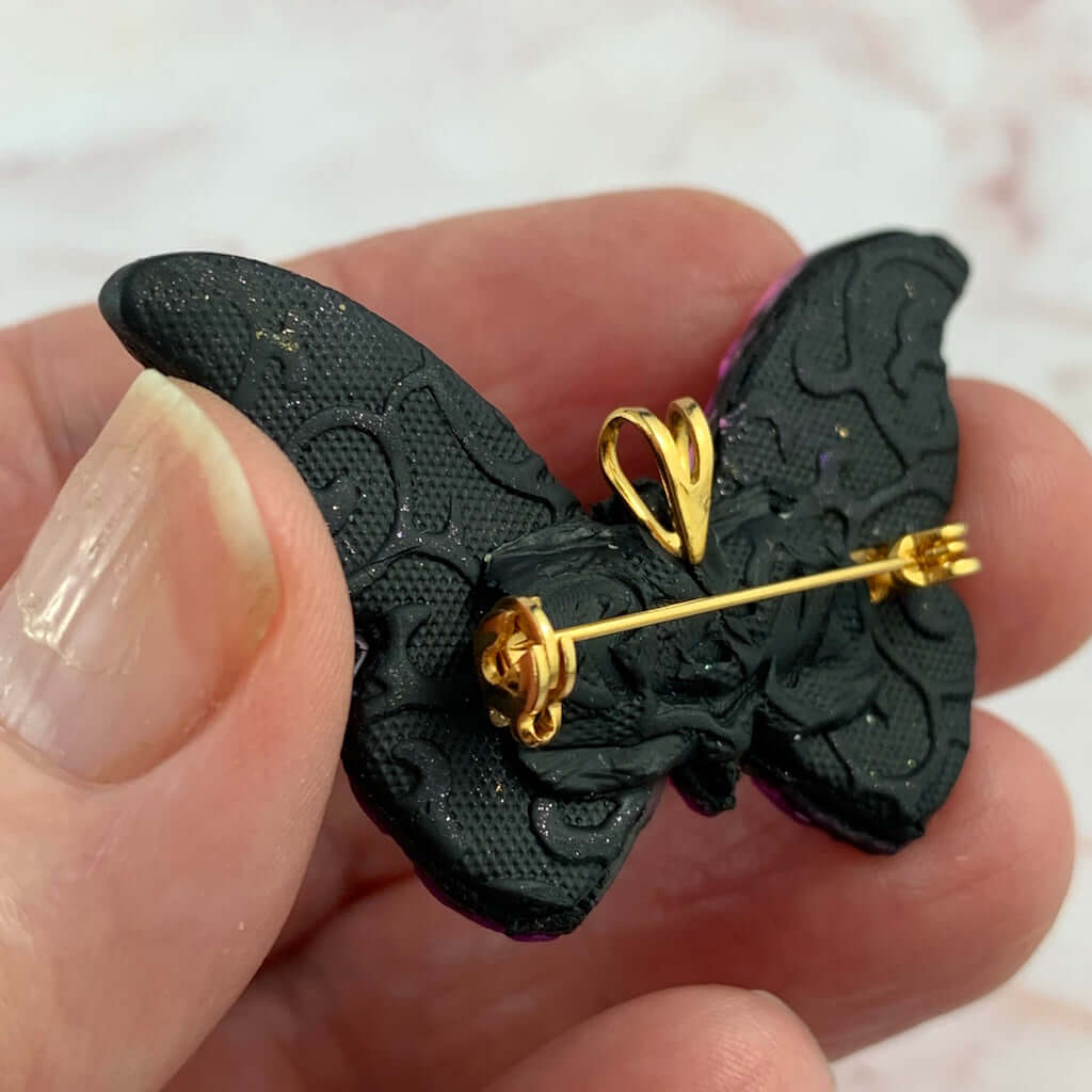 Back detail of butterfly brooch pendant showing embossed texture and secure pin clasp handmade jewellery