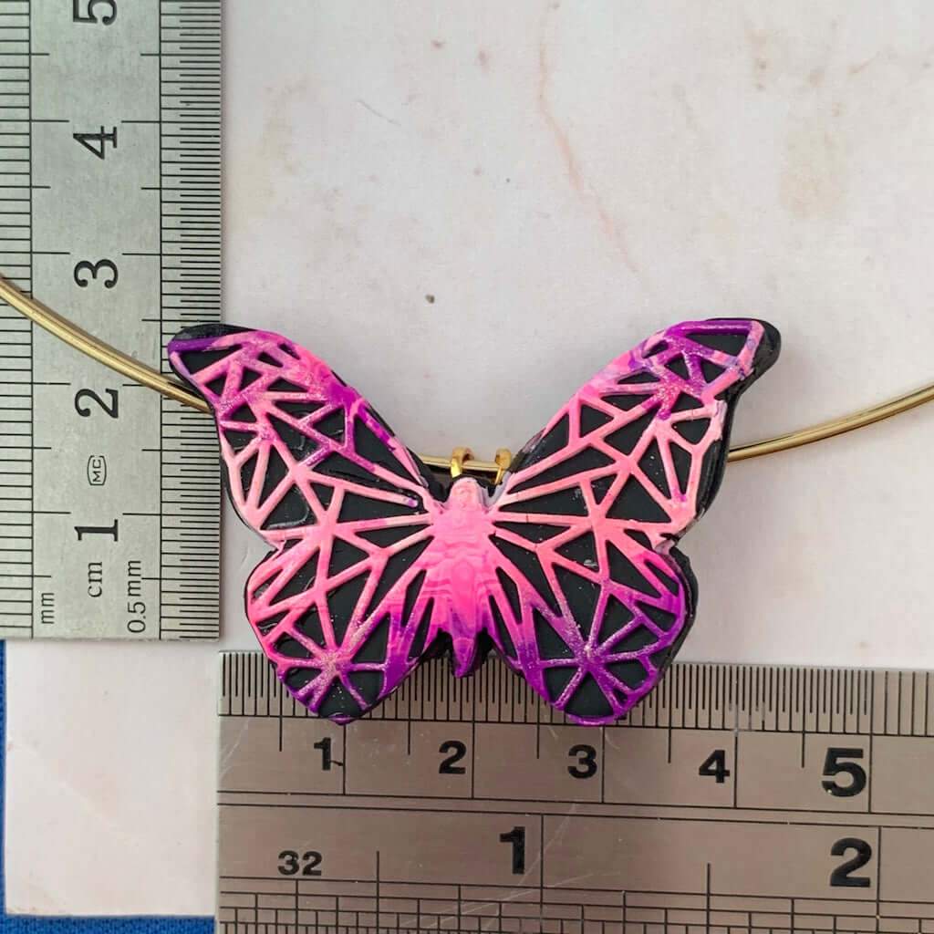 Size reference of butterfly pendant brooch with geometric pattern, handmade jewellery dimensions shown. Size of pendant/broach with raised pattern 2 1/2 cm *4 1/2 cm