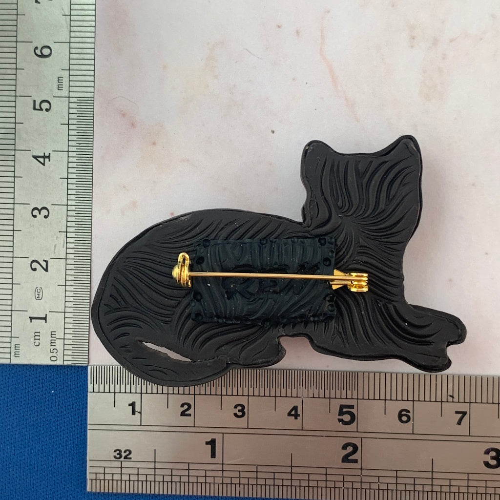 Back view of handmade cat brooch showing secure gold locking pin and textured finish