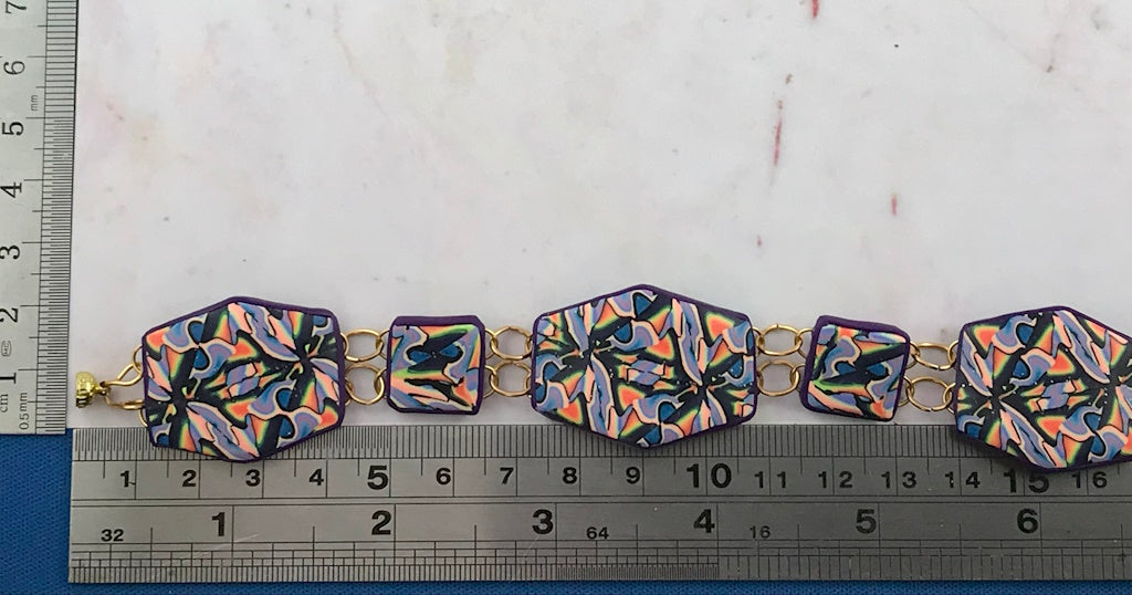 Handmade colourful geometric polymer clay link bracelet shown with ruler for size reference by Rennique Australia.