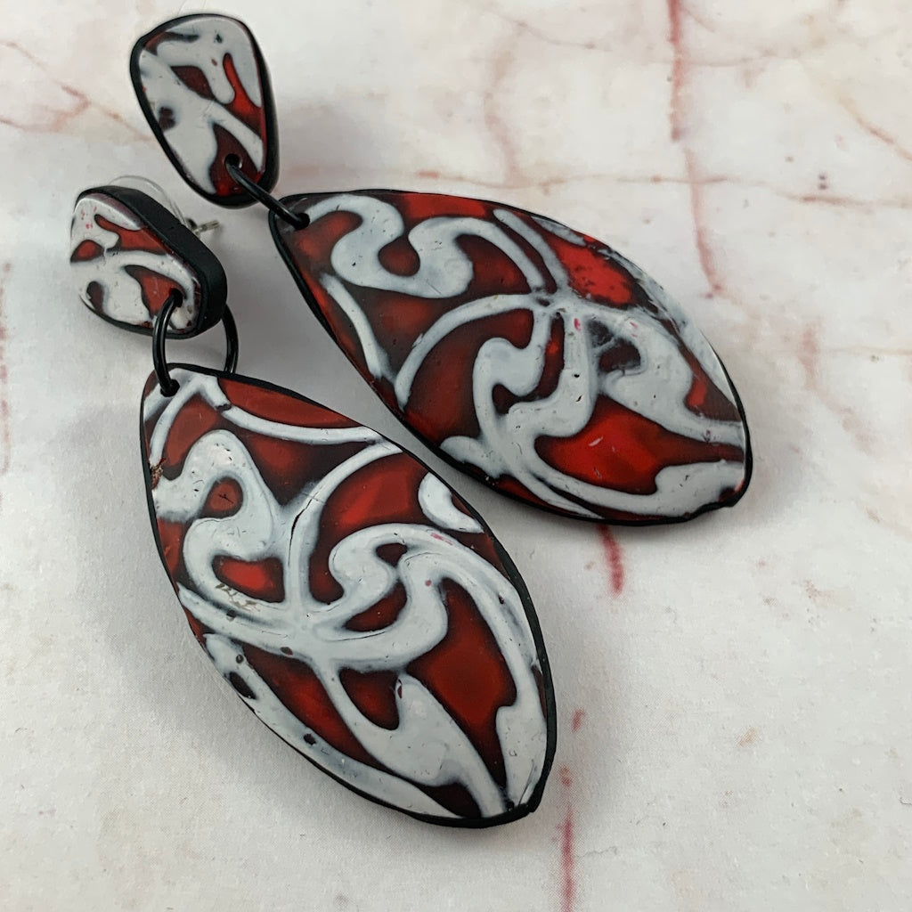 Red and white abstract teardrop statement earrings with black trim