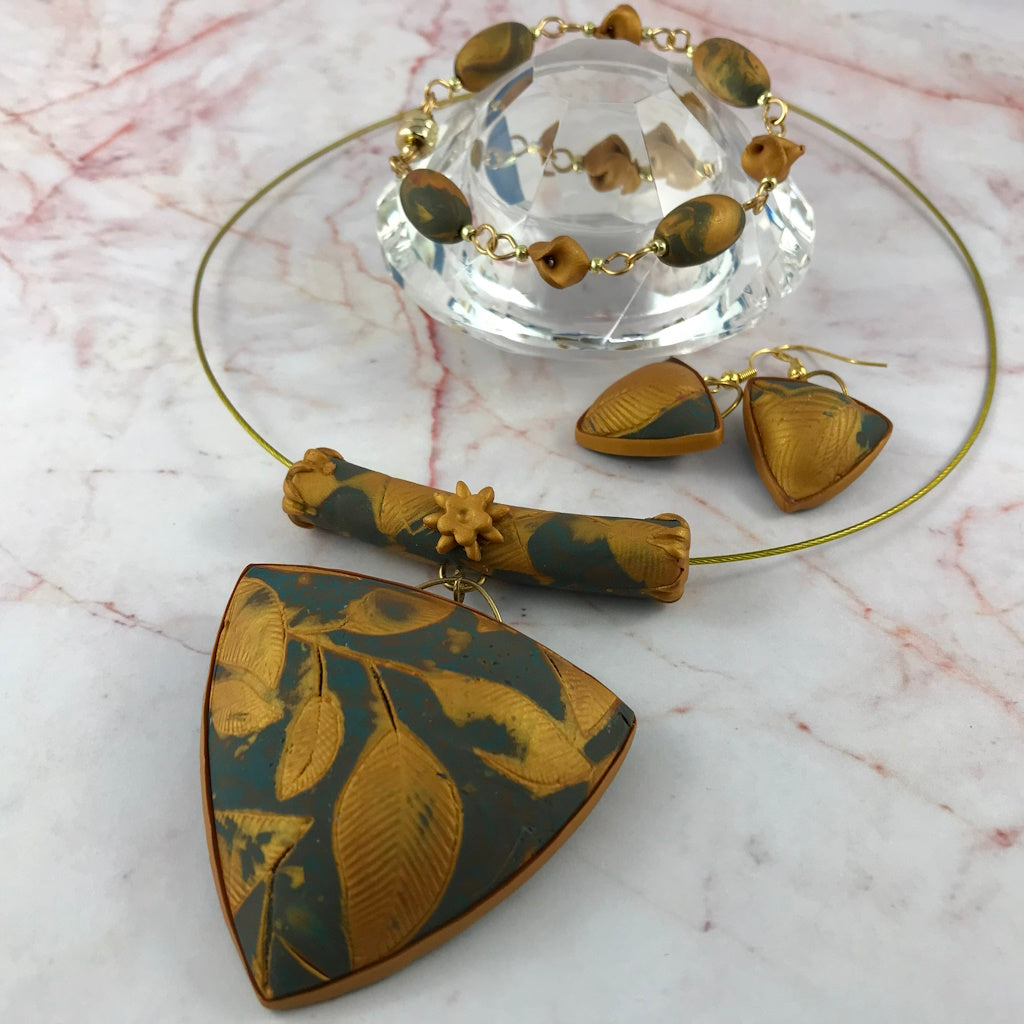 Complete handmade blue and gold jewellery collection with pendant necklace, bracelet and matching earrings.
