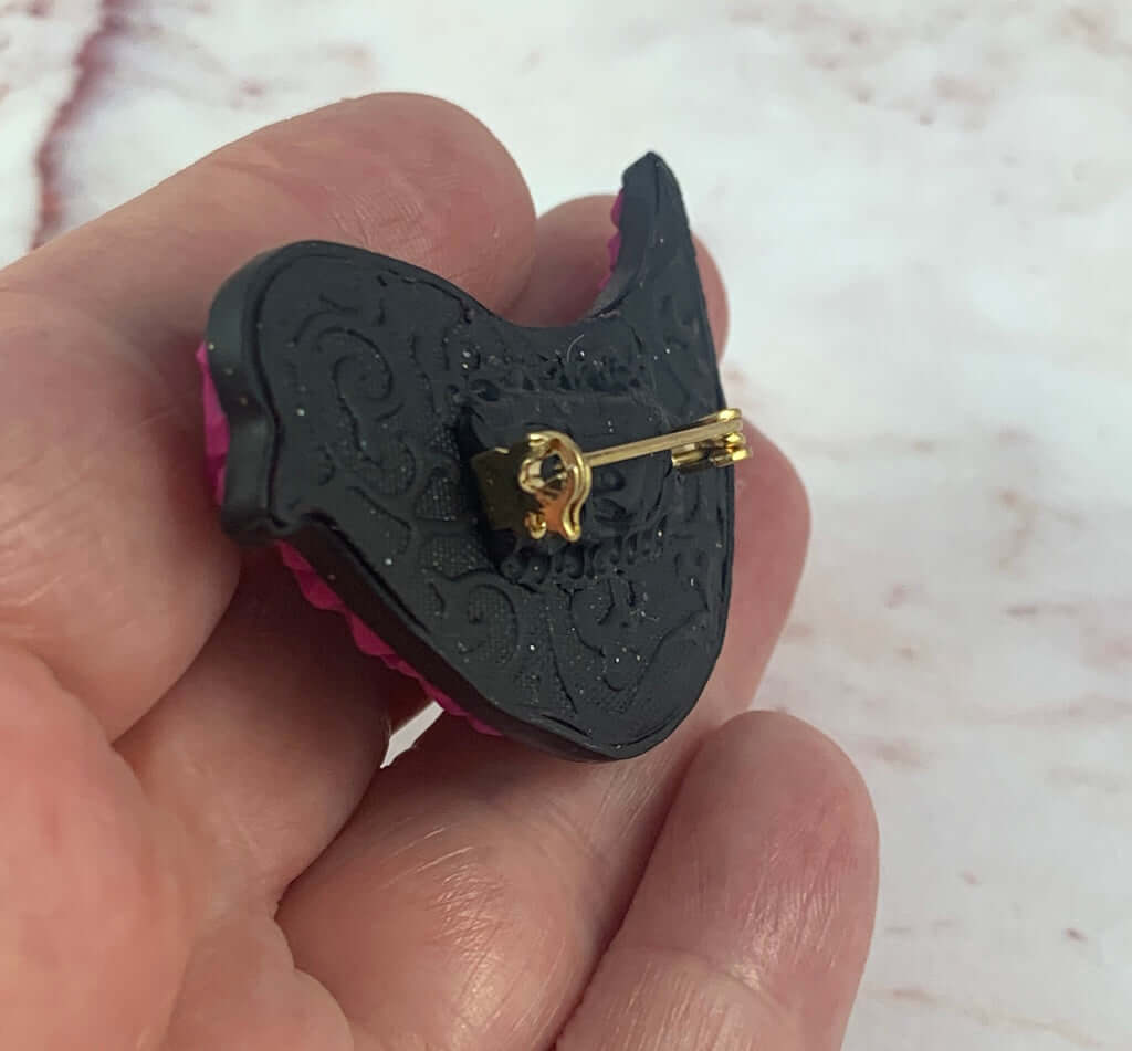 Handmade pink and purple bird brooch wearable art jewellery by Rennique, featuring raised pattern and curved shape