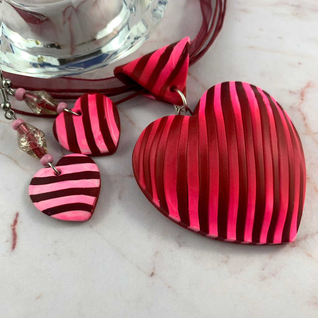 Handmade pink and red heart jewellery set featuring a striped statement pendant necklace and matching drop earrings by Rennique Australia.