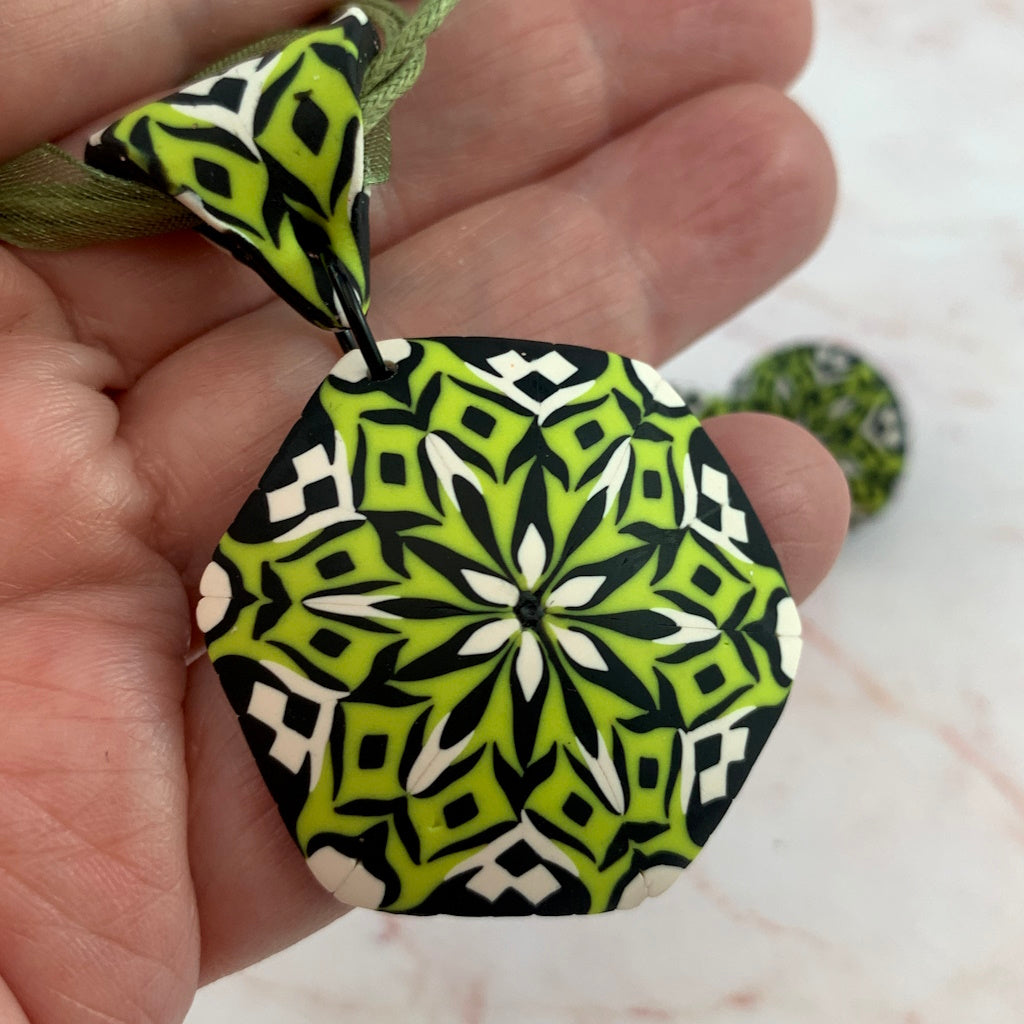 Rennique statement polymer clay pendant necklace featuring a lime green, black and white kaleidoscope mandala design.
