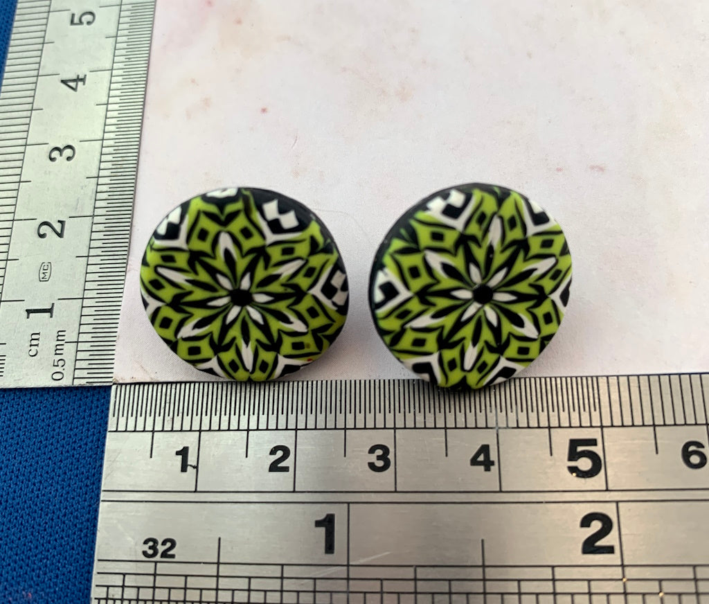 Rennique lime green, black and white polymer clay stud earrings with symmetrical floral mandala pattern and round statement design.