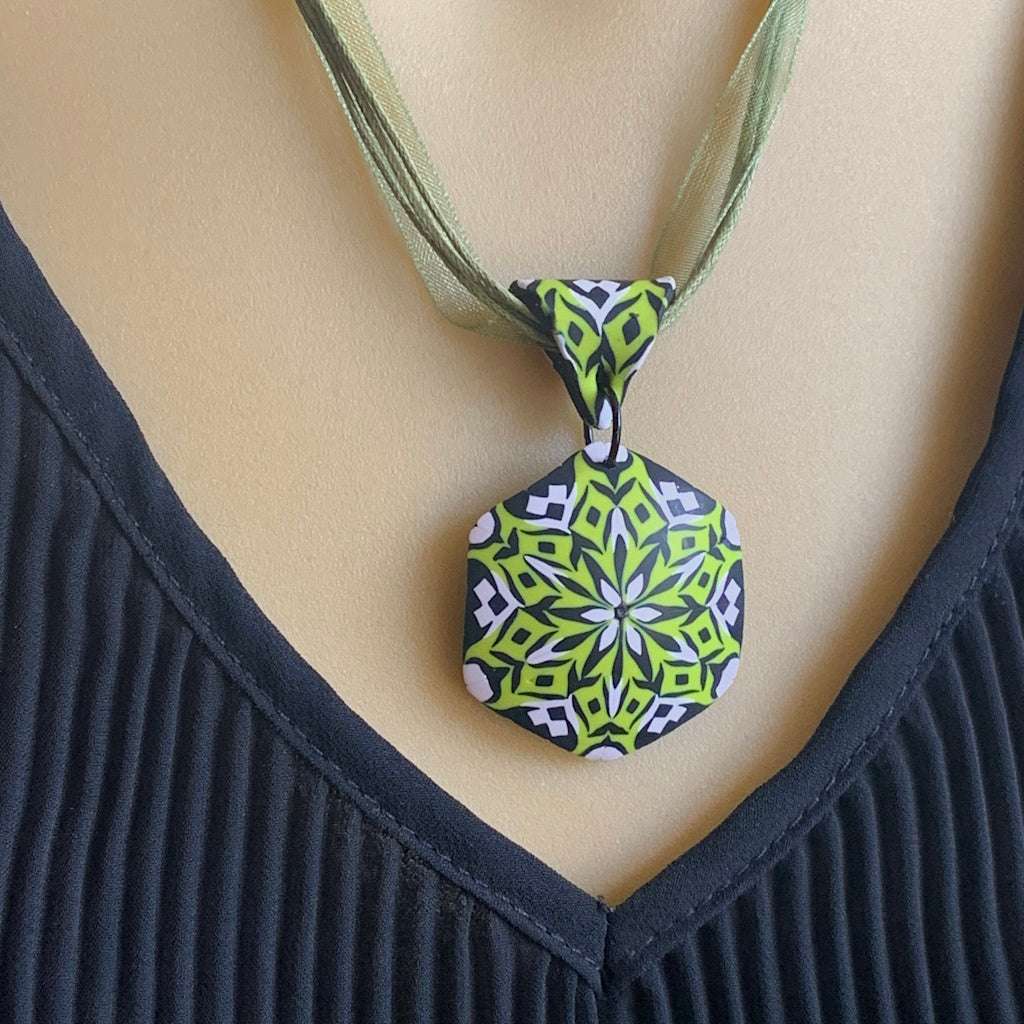 Rennique handmade polymer clay pendant necklace in lime green, black and white shown as a statement fashion accessory.