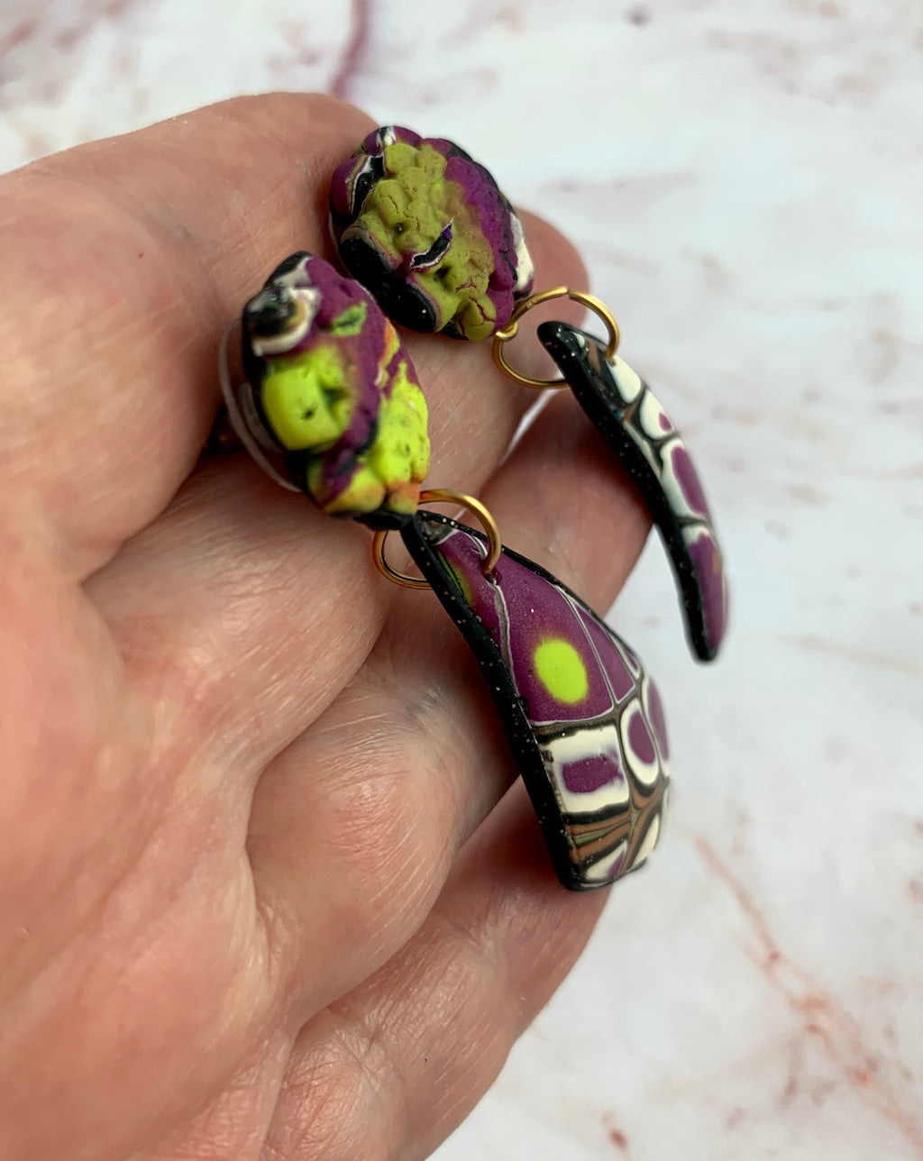 Side profile of long artisan earrings showing gentle curved shape and lightweight design.