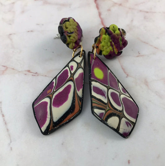 Handmade one-of-a-kind long polymer clay earrings in red-purple, white, black, and mustard front view by Rennique.