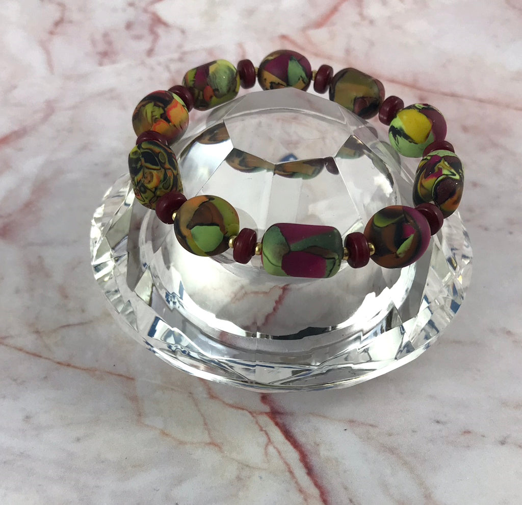 Handmade one-of-a-kind polymer clay bracelet featuring contemporary patterned beads in summer tones by Rennique Australia.