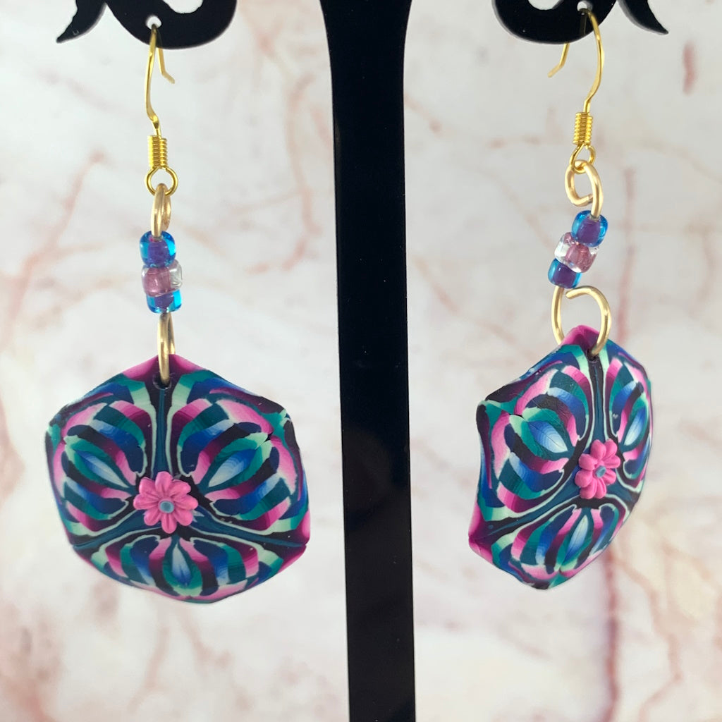 Pink flower feature statement earrings with bold geometric floral design in blue purple and teal tones