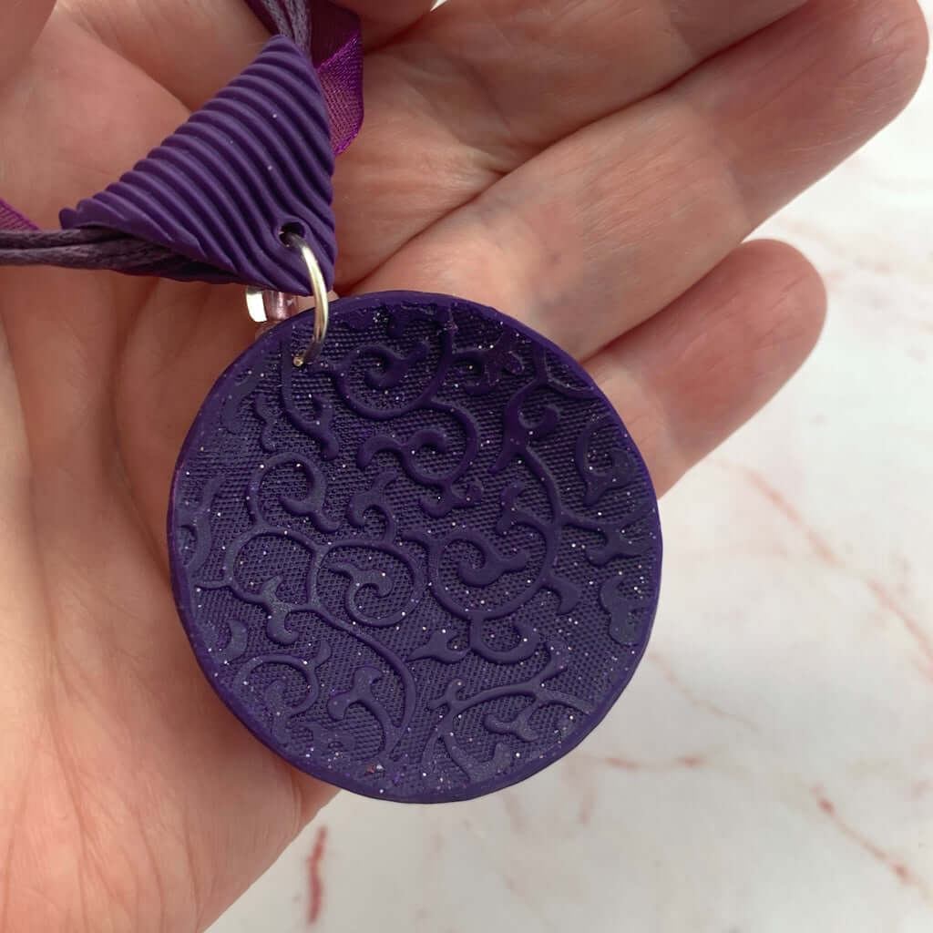 Back detail of pink purple feature pendant showing embossed texture and handmade polymer clay craftsmanship