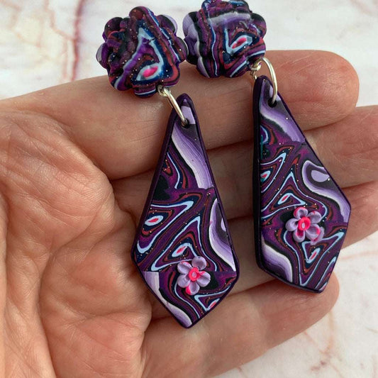 Close-up of Rennique handmade purple marbled earrings featuring delicate 3D flower embellishment.
