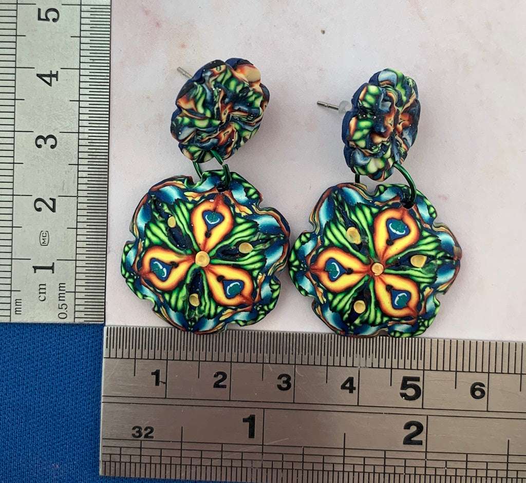 Australian artist made Rennique statement earrings with floral mandala design shown with ruler for size reference.