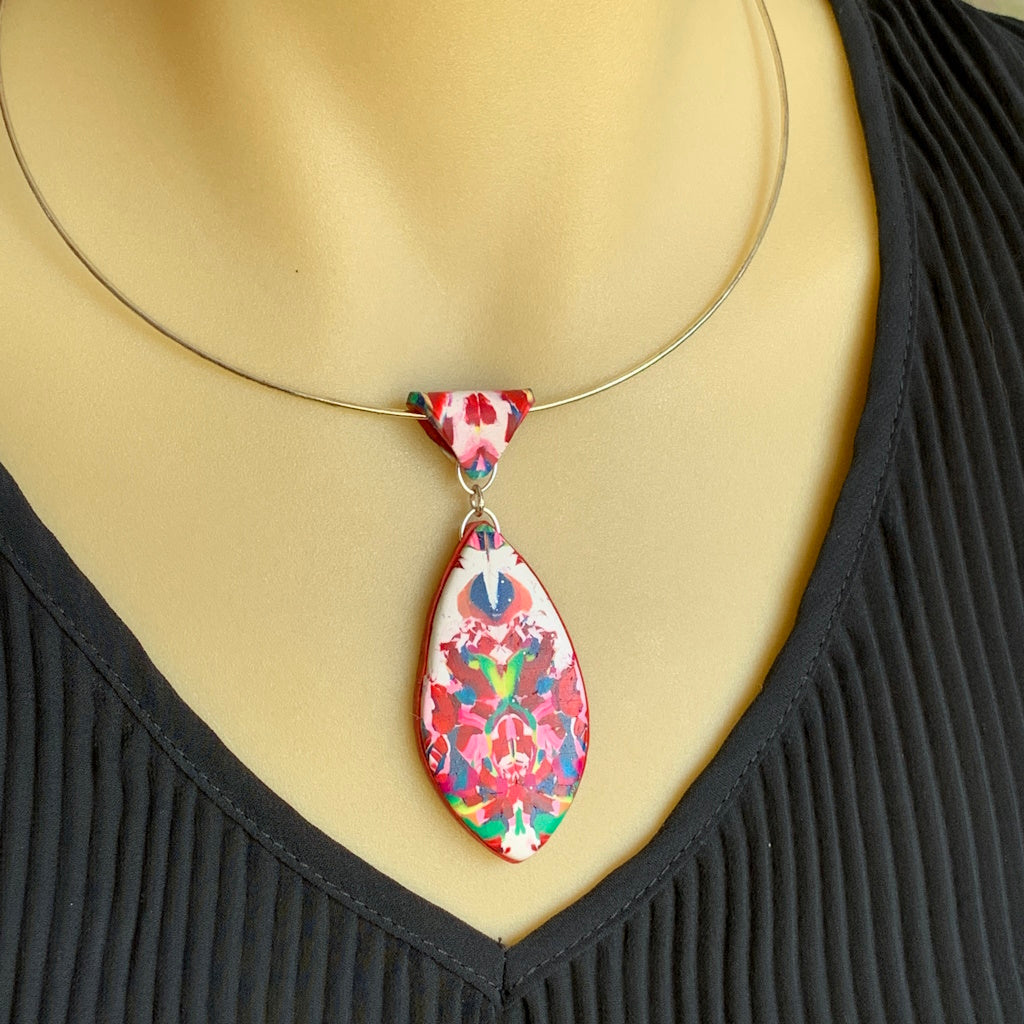 Rennique avant garde polymer clay necklace worn on mannequin with graphic noir design high contrast crimson accents abstract geometric statement jewellery