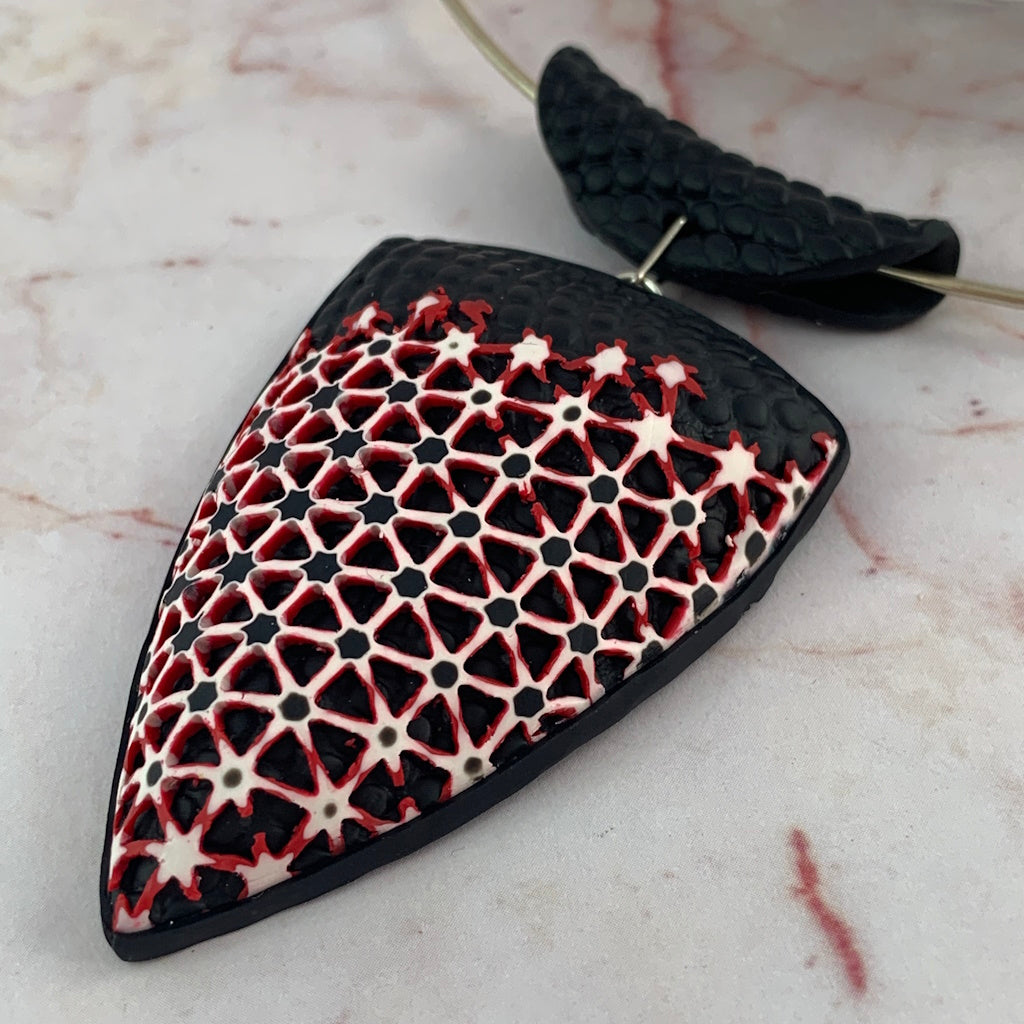 Rennique black red white geometric pendant close up polymer clay jewellery intricate patterned surface bold statement artisan handmade