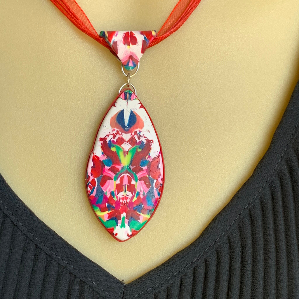 Rennique contemporary studio jewellery polymer clay necklace close up with graphic noir pattern high contrast crimson accents avant garde design