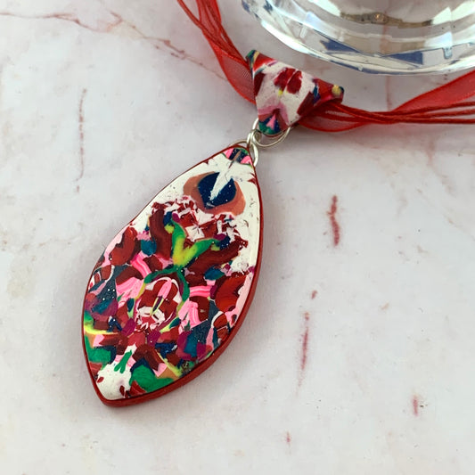 Rennique graphic noir polymer clay pendant featuring high contrast crimson accents and abstract geometric design modern avant garde statement jewellery close up