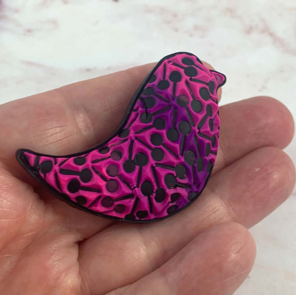 Pink and purple bird brooch in hand, lightweight handmade polymer clay statement jewellery by Rennique Australia