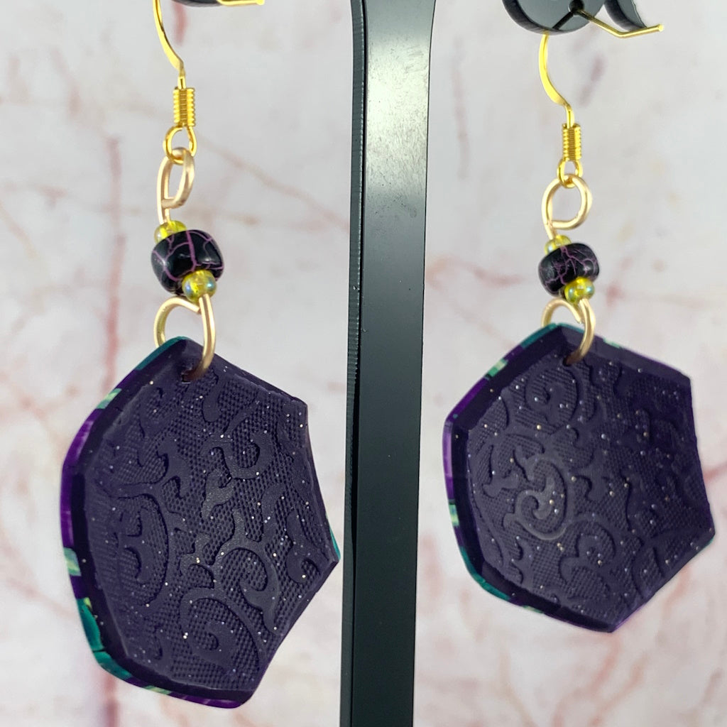 Back view of Rennique Studio wearable art earrings showing embossed texture and handcrafted polymer clay design
