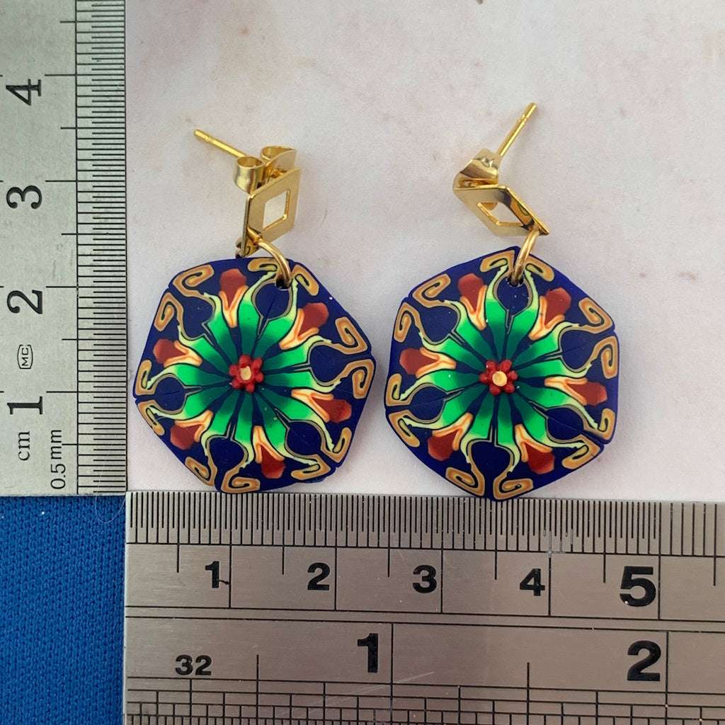 Size reference of Rennique tropical flower-inspired blue and green statement earrings with ruler for scale.