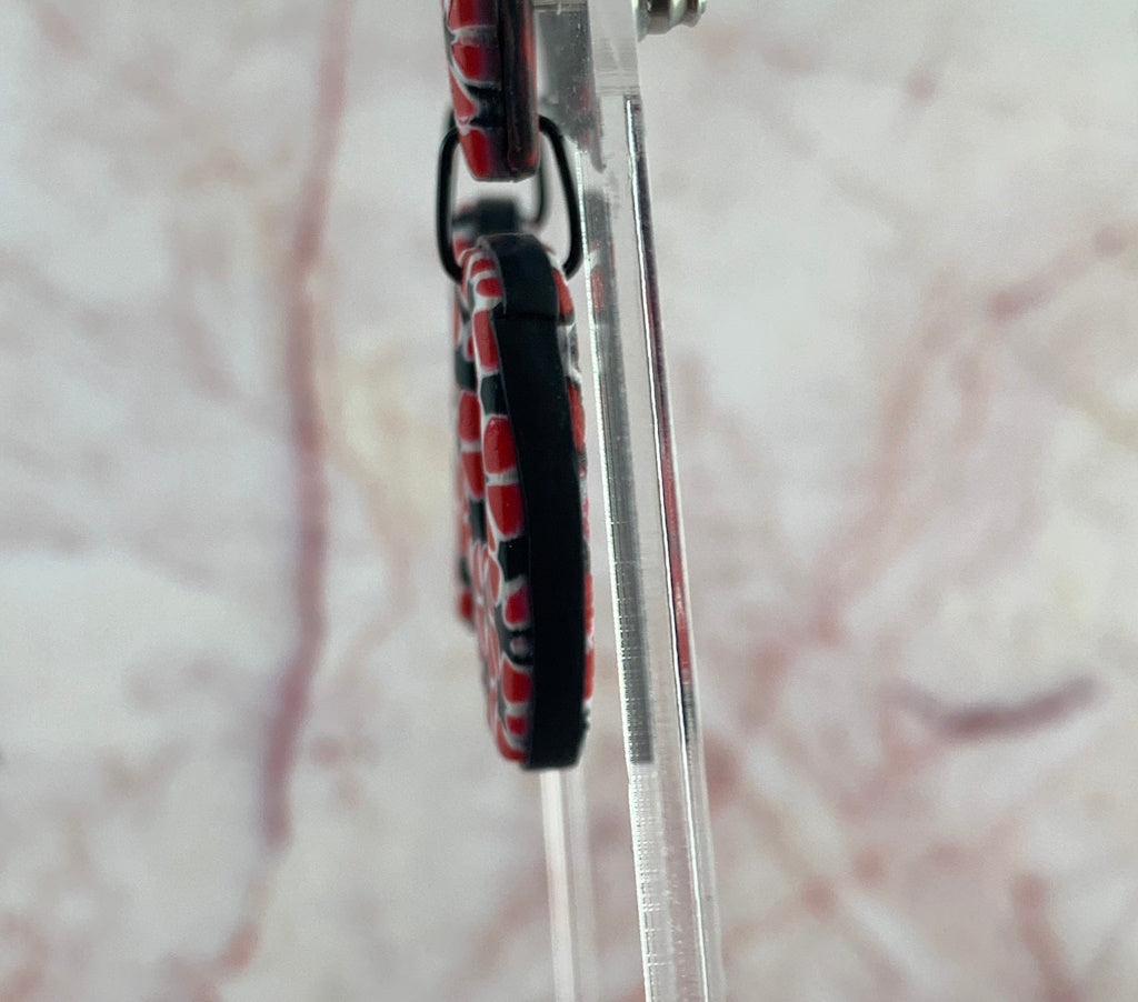 Rennique handcrafted polymer clay necklace red black white geometric pendant side view vivid marbled clay artisan design