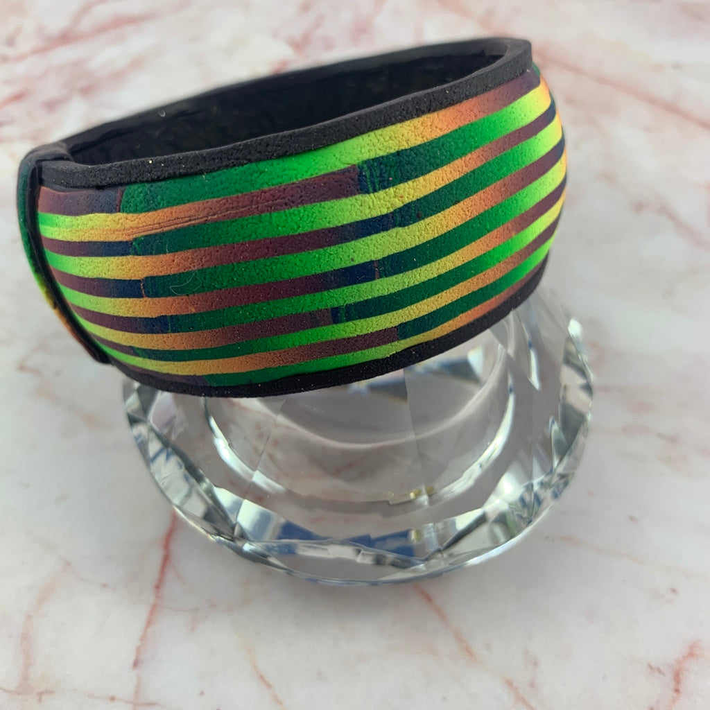 Handmade ladies striped bangle bracelet by Rennique in green gold and purple tones.