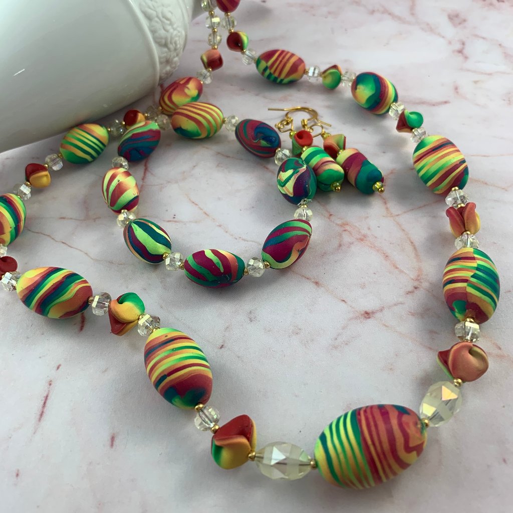 Award winning Rennique hand sculpted multicolour statement jewellery set featuring handmade necklace and matching earrings with vibrant abstract striped beads and crystal accents for women.