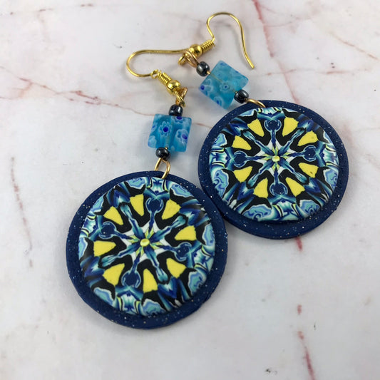 Handmade round blue and yellow geometric polymer clay earrings front view by Rennique.