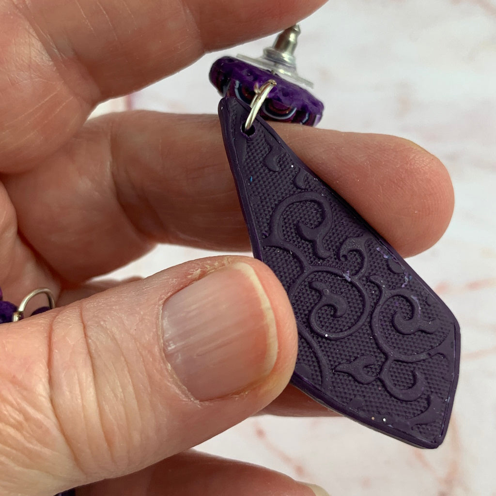 Back view of Rennique purple polymer clay earrings with elegant embossed textured finish and handcrafted detail.