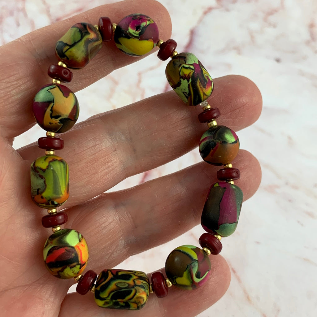 Close-up of handcrafted polymer clay bracelet beads showing intricate layered pattern and texture detail.