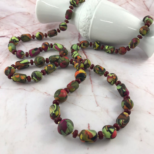 Handmade one-of-a-kind long polymer clay necklace by Rennique featuring 51 artisan beads in summer tones.