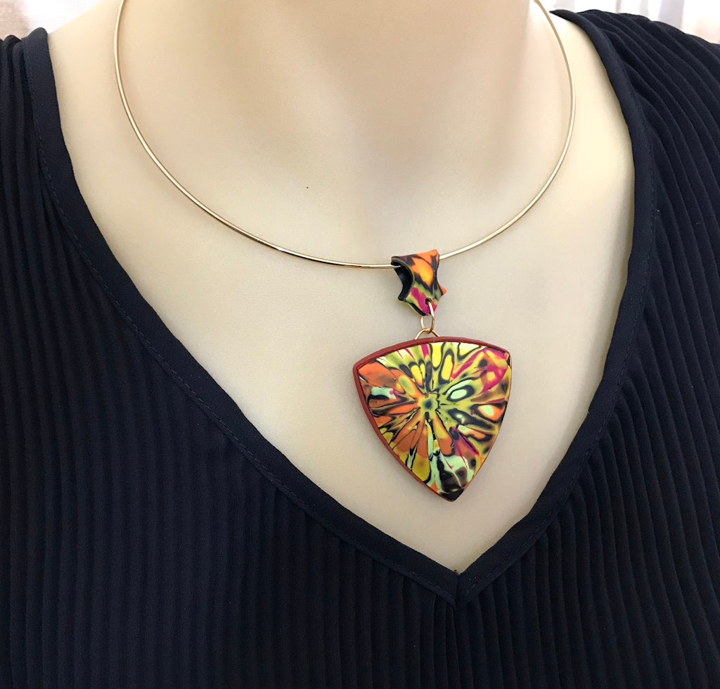 Handmade summer pendant necklace worn close to neckline with textured artisan finish.