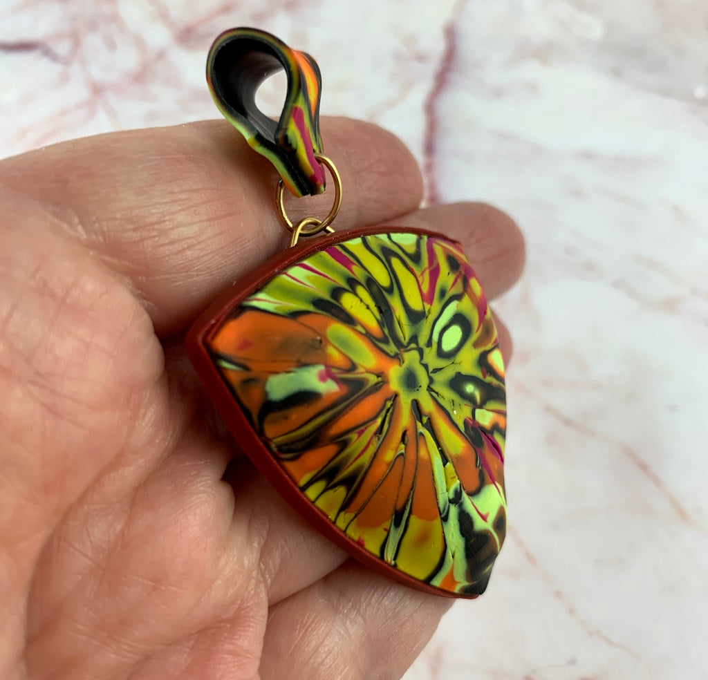 Side close-up view of curved handmade pendant showing air-filled sculptural form.