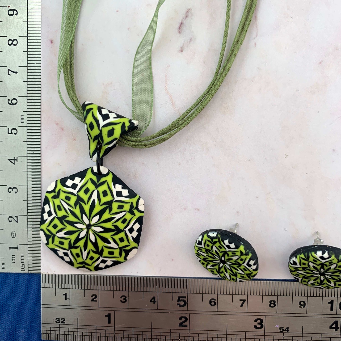 Rennique handcrafted polymer clay pendant necklace and matching stud earrings in lime green, black and white geometric mandala design with size reference.
