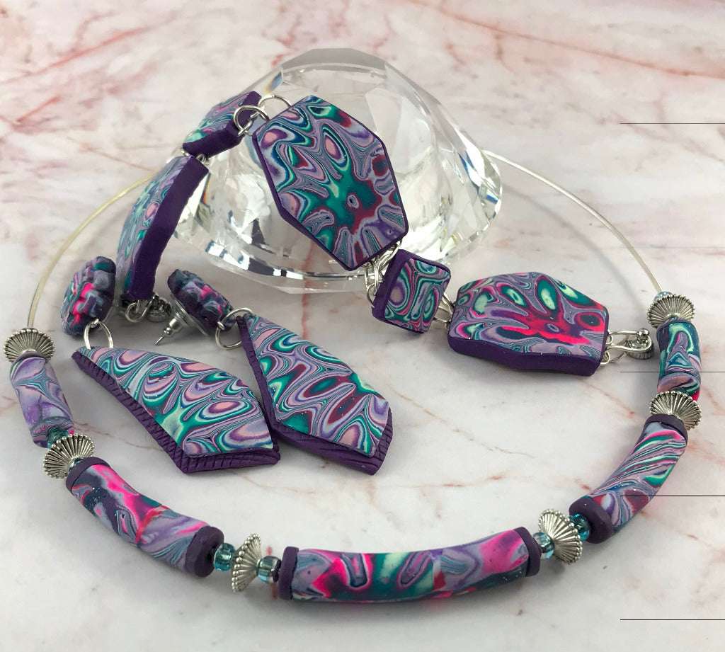 One-of-a-kind handmade jewellery set with statement heart pendant, geometric bracelet and marbled drop earrings in purple, aqua and pink polymer clay, made in Australia