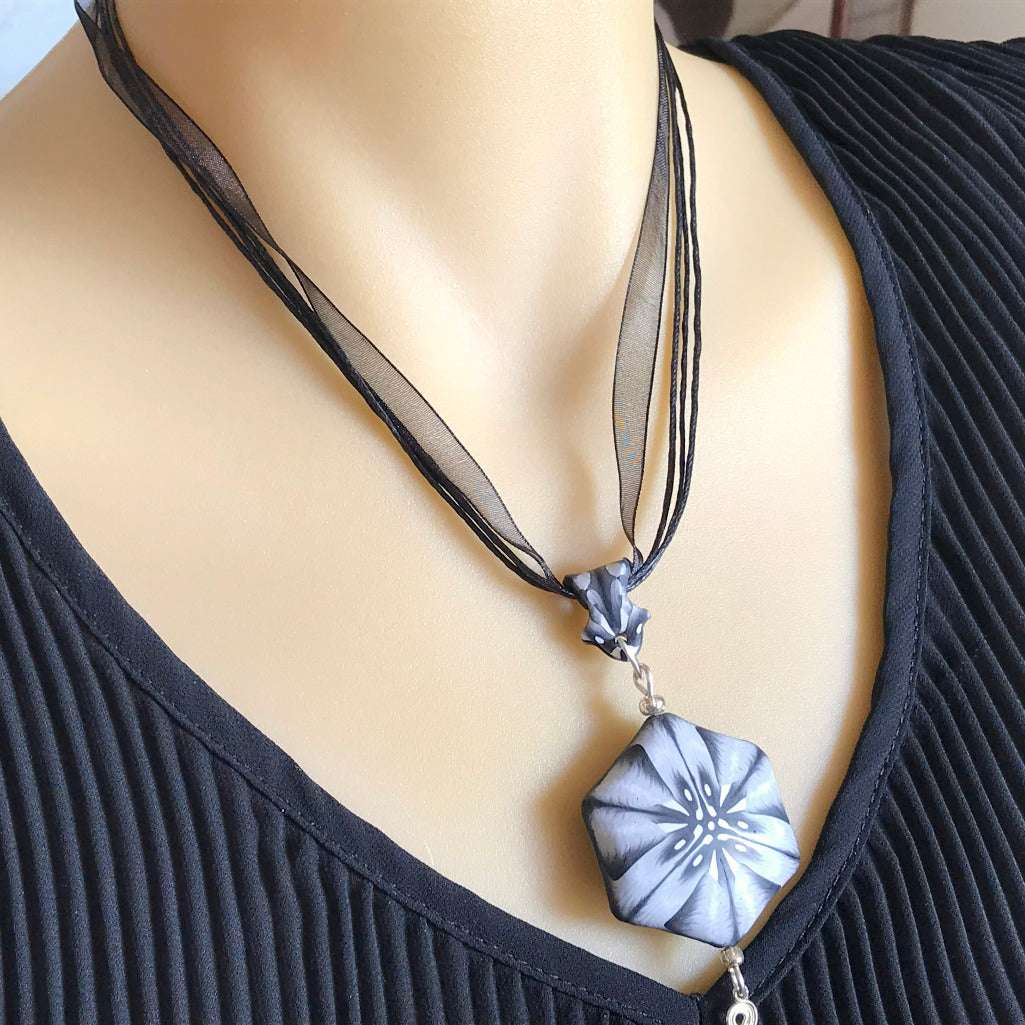 One of a kind black white grey polymer clay pendant necklace worn with black ribbon cords, handmade artisan jewellery Australia