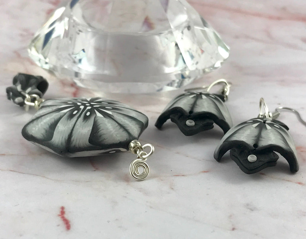 Handmade black white grey polymer clay jewellery set flat lay with statement pendant and matching curved earrings, artisan made in Australia