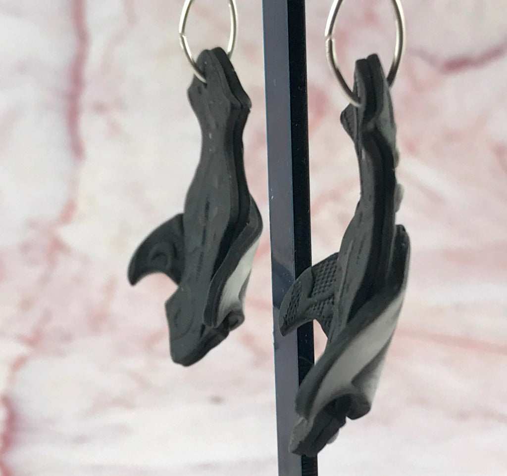 Side view of handmade black white polymer clay drop earrings with curved sculptural design and silver hook fittings, artisan jewellery Australia