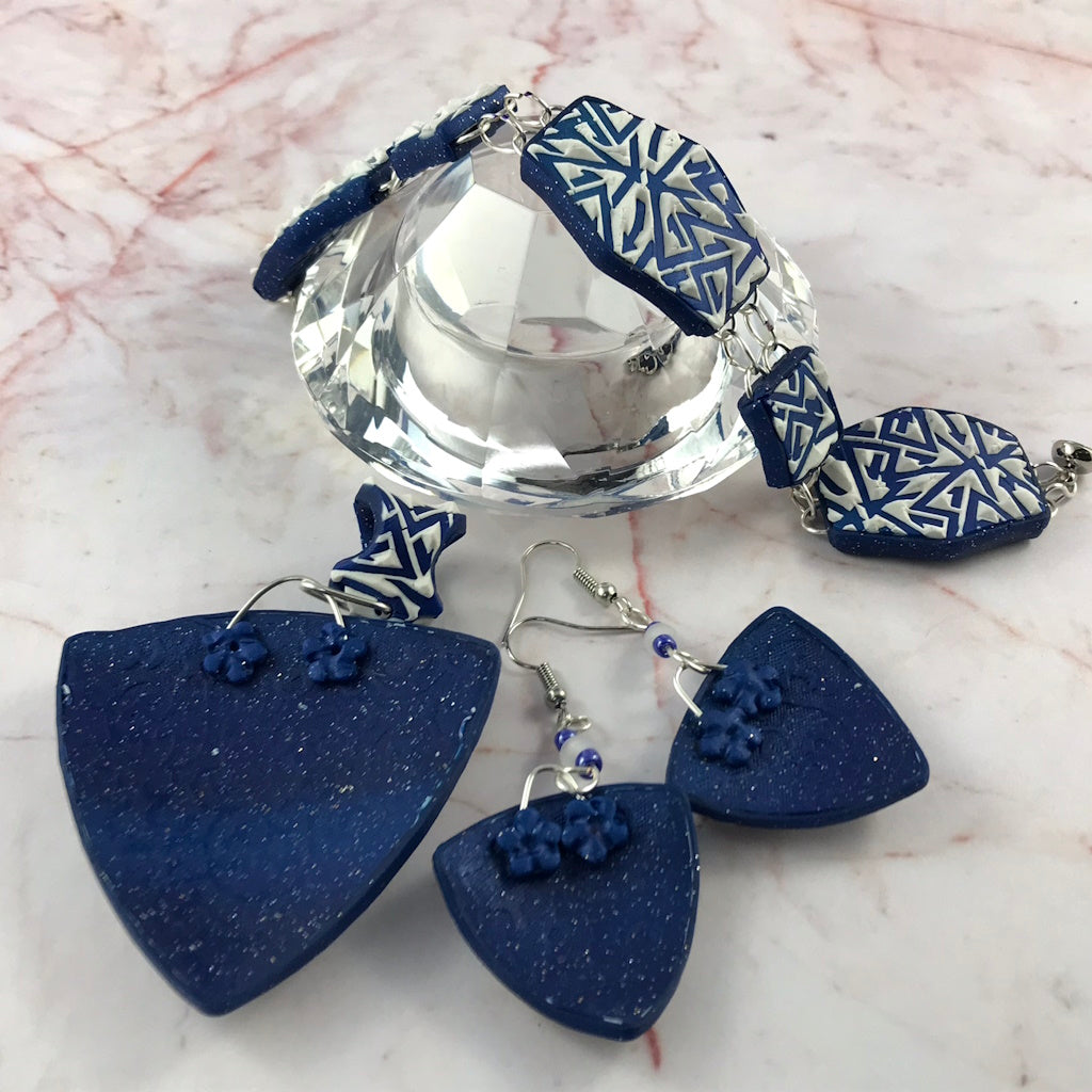 Back view of blue polymer clay statement earrings showing smooth navy textured artisan finish.