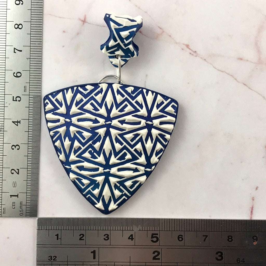 Blue and white polymer clay pendant shown with ruler for accurate size reference and product dimensions.