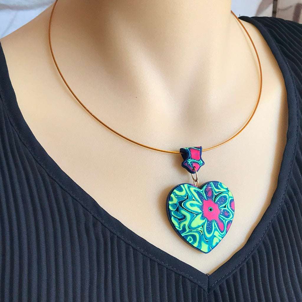 Close-up of Colour Burst Flower heart pendant necklace worn on model, bold handmade polymer clay statement jewellery Australia