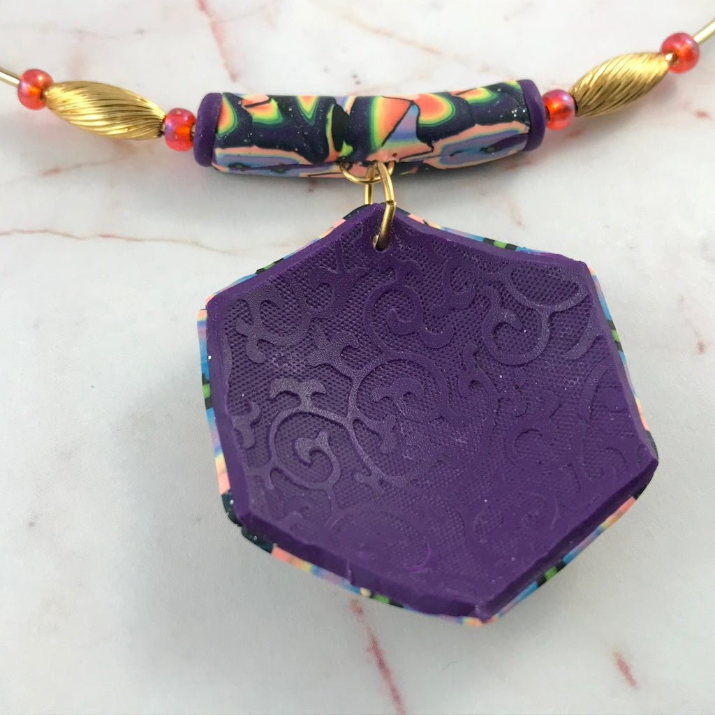 Back view of handmade colourful statement necklace showing cord and clasp detail.